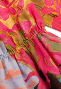 Multikleurige bloemenstof met felle roze bloemen, groene accenten en zachte blauwe wolken. Heeft een geraffineerde taille en een soepele textuur.