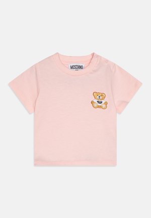 Lyserød baby-T-shirt med korte ærmer, Moschino-label og lille broderet bamse, der holder et knogle mærket "TOY" på brystet.