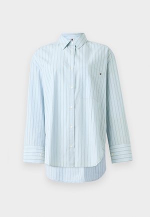 Šviesiai mėlynas marškiniai su vertikaliomis baltomis ir auksinėmis juostelėmis, ilgomis rankovėmis, krūtinės kišene ir mažu prekės ženklu ant apykaklės.