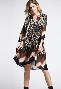 Leopardenmuster-Kleid aus leichtem Stoff, mit V-Ausschnitt, Dreiviertelärmeln, tailliertem Schnitt und einem fließenden Rock mit dunklem Saum.