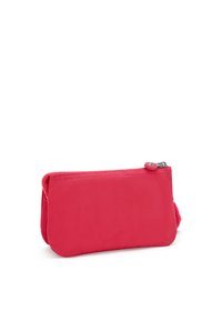 Roze stoffen zakje met een gladde textuur, ritssluiting en een kleine zijlus voor bevestiging. Compact rechthoekig ontwerp.
