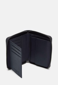 Granatowy skórzany portfel z zamknięciem na suwak. Posiada wiele przegródek na karty, kieszeń na monety oraz gładką fakturę. Minimalistyczny design.