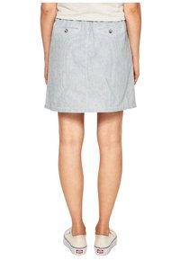 Džínová sukně s vertikálními bílými a modrými pruhy, dvěma zadními kapsami a stříbrnými knoflíkovými detaily. Rovný střih, délka nad kolena.