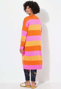 Cardigan lungo a maglia caratterizzato da ampie strisce orizzontali rosa, arancioni e gialle. Presenta un orlo a coste e una vestibilità morbida con maniche lunghe.