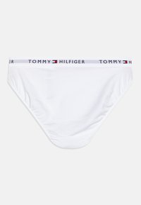 Weiße Baumwollunterhose mit einem weichen elastischen Taillenbund, der das "TOMMY HILFIGER"-Logo und einen roten und blauen rechteckigen Akzent zeigt.