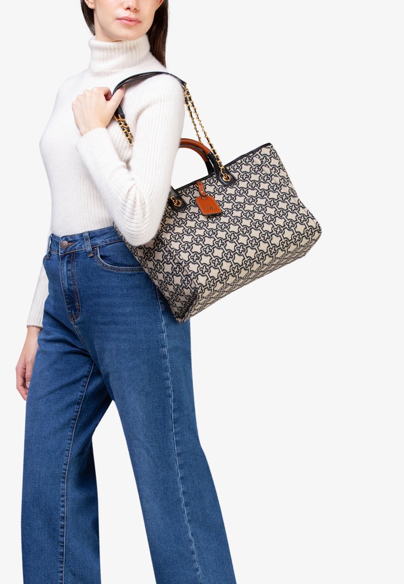 Borsa a tote con motivo beige realizzata in tessuto, con accenti neri e hardware dorato. Presenta un'etichetta in pelle removibile e una tracolla a catena.