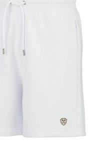 Weiße Baumwollmischung-Shorts mit elastischem Bund, verstellbarem Kordelzug, seitlichen Taschen und kleinem beigen Logo-Patch auf der unteren linken Seite.