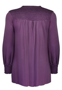 Violetti pitkähihaine paita, jossa on smock-detailit harteilla ja hihoissa, ominaisuuksina pyöreä pääntie ja valuvakangas.