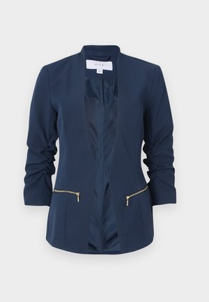Blazer bleu marine en tissu lisse, avec un col châle, des manches longues et deux poches zippées à l'avant avec des accents dorés.