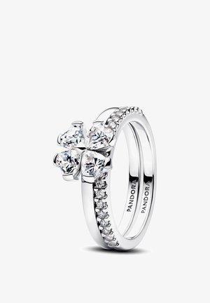 Bague Pandora en argent avec un groupe en forme de fleur composé de quatre pierres claires taillées en forme de cœur et des pierres plus petites le long de l'anneau.