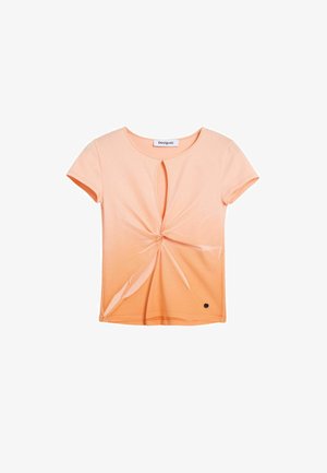 Kurzärmliges, hellpfirsichfarbenes T-Shirt aus weichem Material mit einem verdrehten Frontknoten und Ausschnitt, mit einem kleinen schwarzen Logoakzent.