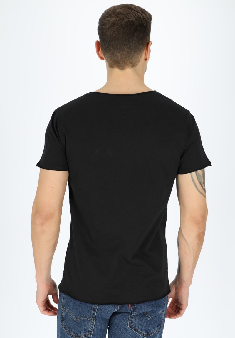 Black short-sleeve t-shirt in a cotton blend, featuring a round neckline and a seamless design. Worn with blue denim jeans.