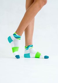 Bunte Knöchelsocken mit weißen, grünen und blauen Mustern. Hergestellt aus einem weichen, dehnbaren Material mit verstärktem Zehenbereich.