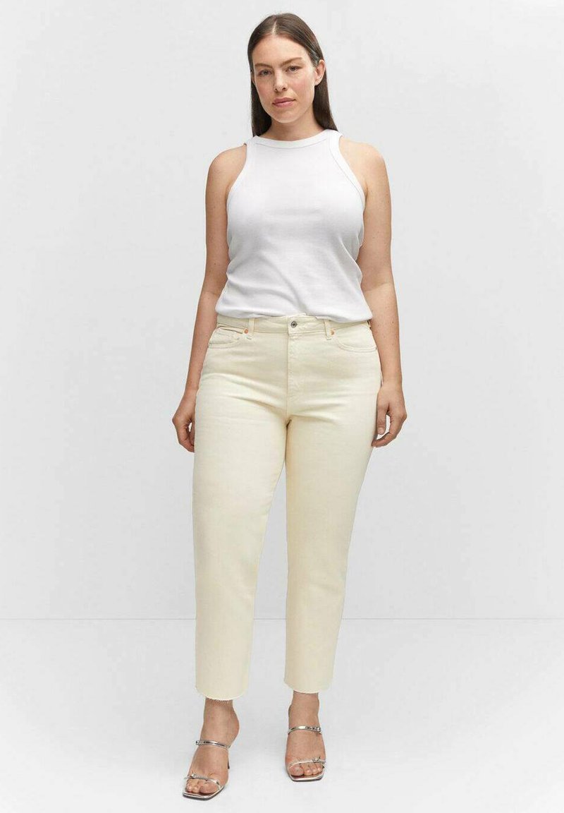 Cremfarbene Jeans mit geradem Bein, ergänzt durch ein weißes ärmelloses Oberteil. Die Hose verfügt über ein klassisches Fünf-Taschen-Design und minimale Nähte.