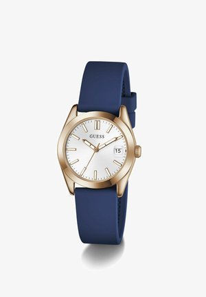 Orologio da polso GUESS in tonalità oro con quadrante bianco, indici dorati, finestra per la data e cinturino in silicone blu navy, segna le 10:10:37.