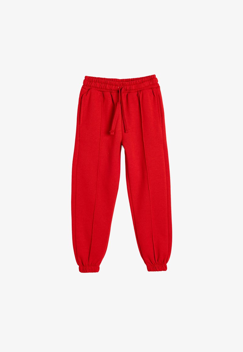Pantalon de survêtement rouge avec une taille élastique et un cordon de serrage, comportant des poches latérales et des poignets fuselés aux chevilles. Tissu doux au toucher.