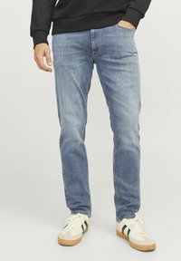 Jeans de mezclilla azul claro con un corte recto, que presentan un diseño clásico de cinco bolsillos y sutiles desgastes en la parte frontal.