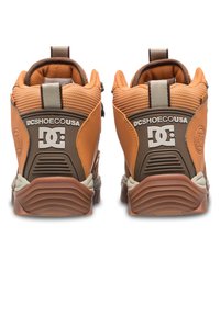 Orange und braune Sneakers mit strukturiertem Finish, gepolstertem Schaft und Gummisohle. Auf der Rückseite ist das DC-Logo prominent angebracht.
