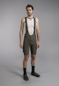 Men's cycling bib shorts in olive green, featuring a fitted design, mesh bib straps, and padded seat for comfort during rides.