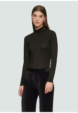 Zwarte lange mouwen turtleneck top gemaakt van een gladde, rekbare stof, gecombineerd met donkere, pluche, wijde broeken. Eenvoudig ontwerp, aansluitende silhoeet.