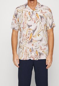 Camicia a maniche corte in colori chiari con un motivo astratto vorticoso in toni di arancione, beige e grigio. Presenta un'apertura con bottoni sul davanti e colletto.