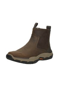 Stivale da caviglia in pelle marrone con suola beige, battistrada nero, maniglie per il tiro e logo Goodyear sul lato della suola.