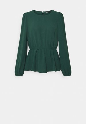 Tume roheline peplum-särgid pikade varrukatega, ümar kaelus ja kogutud vöökoht. Valmistatud pehmest kangast, millel on sile tekstuur.