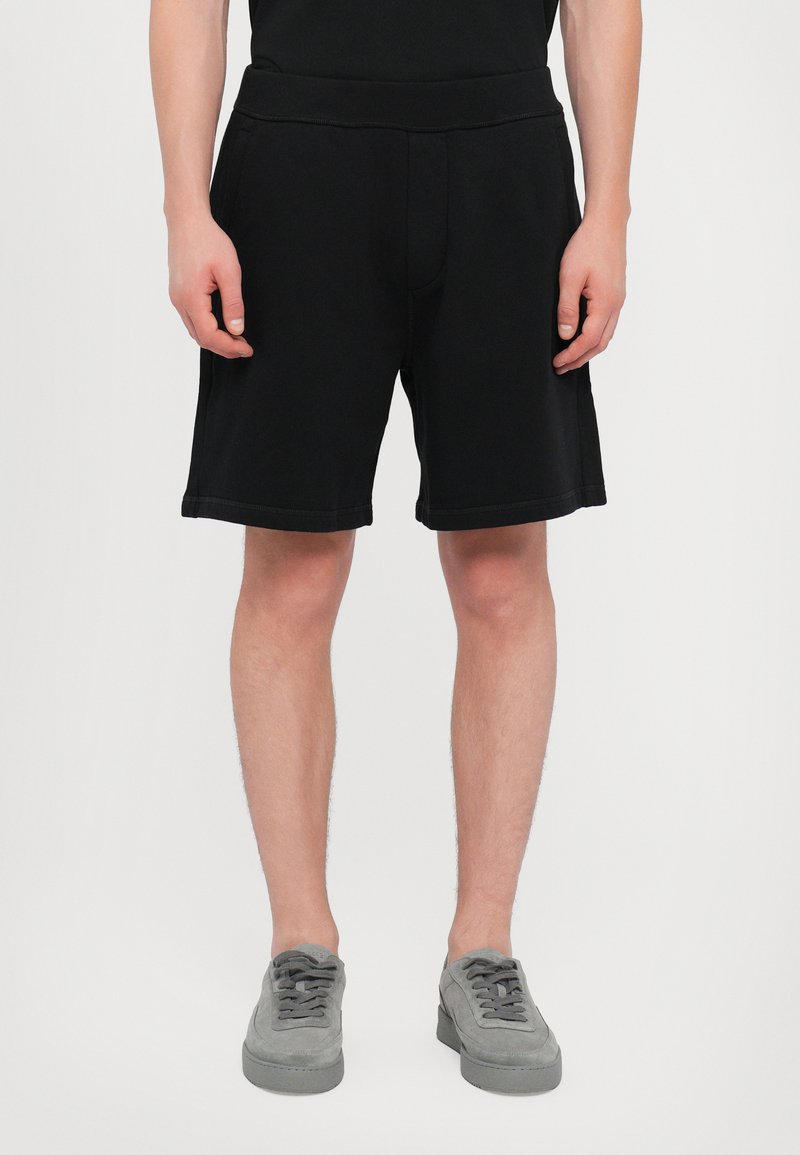 Shorts noirs en tissu doux, dotés d'une taille élastique, de poches latérales et d'une coupe décontractée. Design simple sans motifs visibles.