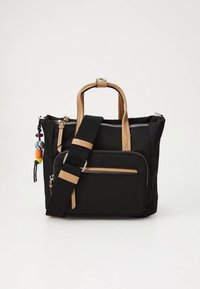 Black fabric tote bag with tan leather handles, an adjustable strap, a front zip pocket, and colorful bead charm.