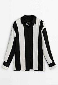 Chemise à manches longues noir et blanc avec des rayures verticales larges et un col classique, étalée à plat sur un fond blanc.