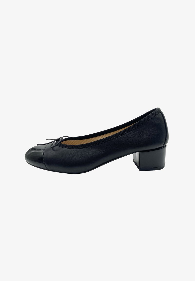 Ballerines en cuir noir avec un bout rond, un cap en cuir verni, un petit talon et un nœud décoratif à l'avant. Texture lisse et design minimaliste.