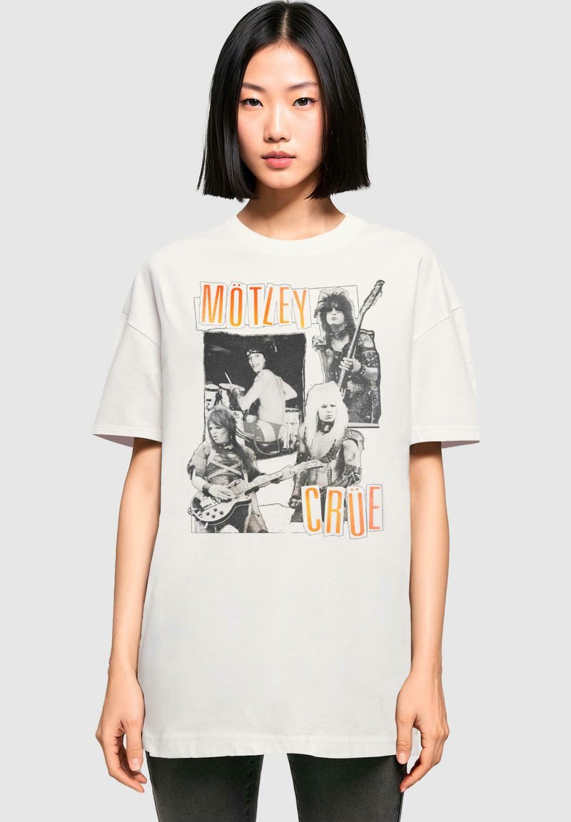 Hvid oversized t-shirt med sort-hvide billeder af musikere og orange "MÖTLEY CRÜE" tekst. Korte ærmer, rund halsudskæring.