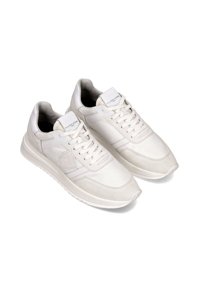 Hvide lædersneakers med en kombination af glat og tekstureret ruskind, med snørebåndslukning og et logo på tungen.