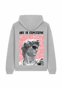 Siva jopa z grafiko marmornega kipa, ki nosi sončna očala in nakit, z napisom "UMETNOST JE DRAGA" na rožnati podlagi.