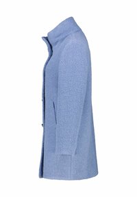 Cappotto azzurro chiaro realizzato in tessuto testurizzato, con colletto alto, tasche laterali e silhouette dritta. Chiusura con bottoni sul davanti.