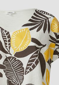 Witte V-hals top met een bruin en geel bladerenpatroon. Korte mouwen, lichte stof en een casual design.