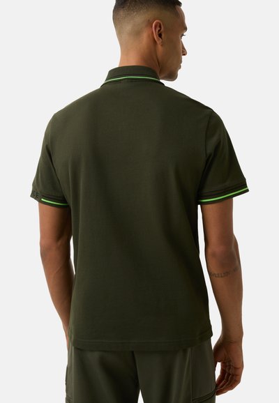 Dark green polo shirt made of cotton, featuring a solid texture, short sleeves with a green accent at the cuffs and collar.