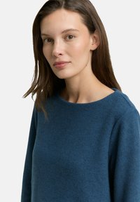 Dunkelblauer Strickpullover mit rundem Ausschnitt und langen Ärmeln, weicher Textur und taillierter Passform.