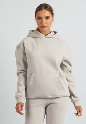 Vaaleanharmaa puuvillainen huppari, jossa on etutasku, nyörikiinnitteinen huppu ja resorit hihansuissa. Yhdistetty samansävyisiin vaaleanharmaisiin housuihin. Pehmeä materiaali.