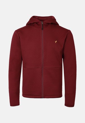Burgundy zip-up hoodie with a textured pattern, lined hood, and front pockets. Features a small gold logo on the left chest area.
