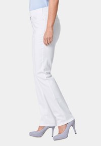 Witte jeans met een rechte pijpdesign, subtiele textuur en een hoge tailleband, gecombineerd met lichtgrijze hoge hakken.