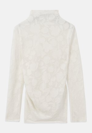 Blusa de manga longa em creme claro com um padrão floral texturizado, apresentando um decote alto e tecido suave com ligeiro caimento nas laterais.