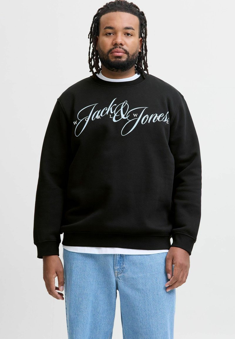 Must be musta suur aqua sinise "Jack & Jones" logo. Omab soonikuid varrukaid ja äärt. Kanda valge kihilise särk ja sinised teksad.