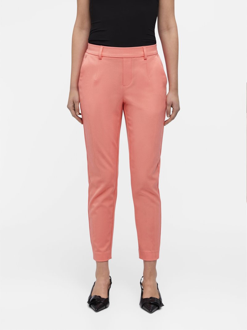 Roze op maat gemaakte broeken met een slim fit, voorzien van zijzakken, een glade textuur en subtiele voorplooien. Gecombineerd met zwarte slingback hakken.