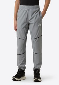Lette, pustende grå treningsbukser med elastisk midjebånd, kontrasterende svarte detaljer og sidelommer. Egnet for aktiv bruk.