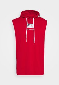 Punainen, hihaton huppari, valmistettu puuvillasta, jossa on edessä logotunniste ja valkoiset nyörit hupussa. Yksinkertainen, rento malli.