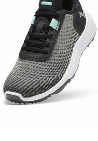 Melnas un pelēkas rakstotas skriešanas kurpes ar teksturētu auduma virsu, baltu starpmēslu un melnu gumijas ārējo zoli. Iezīmējas ar tirkīza akcentiem un auklām.