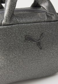 Gray textured synthetic handbag with two handles, featuring a black Puma logo accent and a zippered opening.