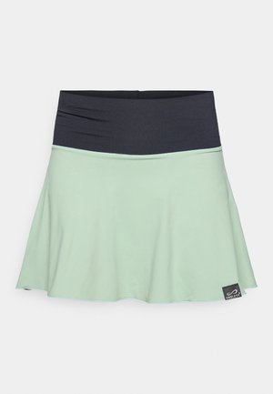 Saia verde-menta clara com um cós preto, design evasé, textura suave e uma pequena etiqueta de marca próxima à bainha.
