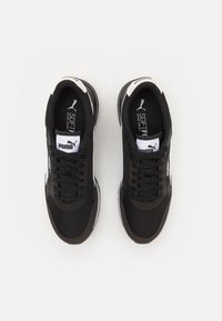 Zapatillas deportivas negras con parte superior de malla, cordones y acentos blancos. Cuenta con una plantilla acolchada y una suela de goma para mayor estabilidad.